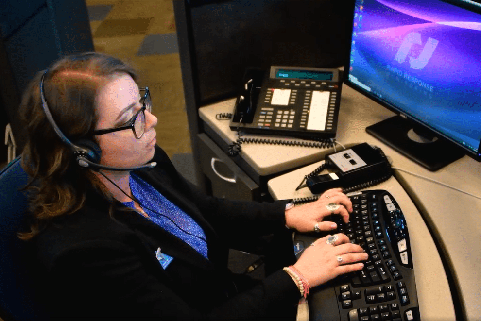 Woman working at professional monitoring center to dispatch authorities in case on trigger from customer's smart home security system\.